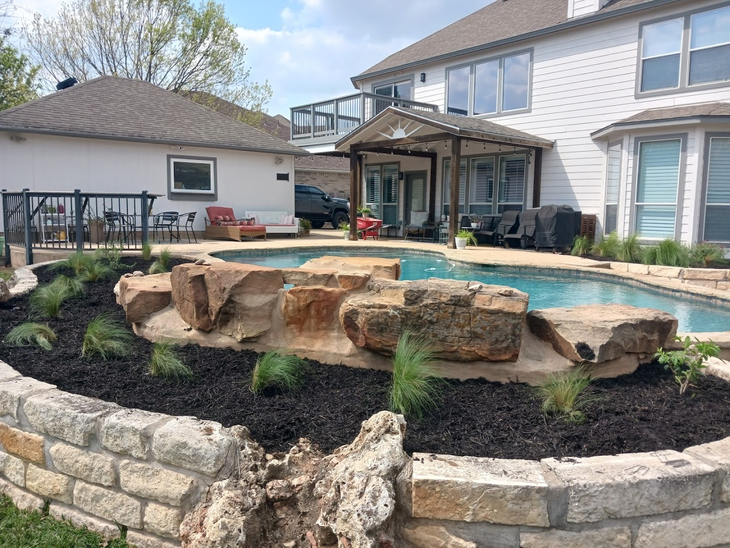 Pool with stone retaining wall and landscaping, Seguin TX